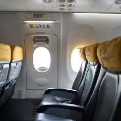 Puste siedzenia w samolocie b737 z żółtymi zagłówkami i oknami.