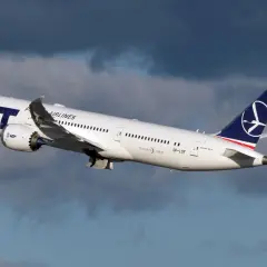 Biały Dreamliner LOT-u wznosi się na tle burzowych chmur. To dumny element polskiej floty lotniczej.