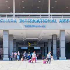Lotnisko w Hurghadzie wita podróżnych. Ludzie z walizkami wchodzą do terminalu.