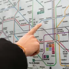 Palec wskazujący na mapę metra w Barcelonie, szukając trasy z lotniska.