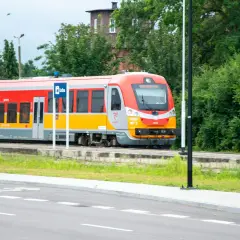 Czerwono-żółty pociąg Polregio na tle zieleni. Czy w Polregio jest rezerwacja miejsc?