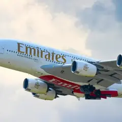 Samolot Emirates wznosi się w powietrze, gotowy do lotu. Zastanawiasz się, ile się leci do Dubaju?