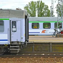 Nowe wagony PKP Intercity z zielonym pasem czekają na pasażerów. Na peronie stoją rowery.