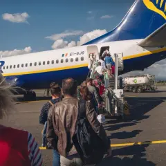 Pasażerowie wsiadają do samolotu Ryanair. Zastanawiasz się, ile kosztuje odprawa na lotnisku Ryanair?