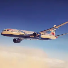Boeing 787-10 British Airways wznosi się ponad chmurami w słoneczny dzień.