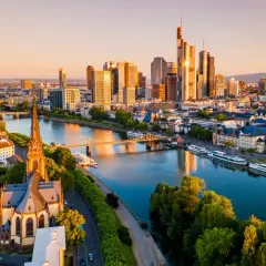 Widok na nowoczesne wieżowce i zabytkowy kościół nad rzeką Men. Tak wygląda Frankfurt o zachodzie słońca.