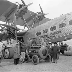 Grupa mężczyzn przy pierwszym samolocie pasażerskim Imperial Airways London. Tankowanie samolotu z beczek Shell.