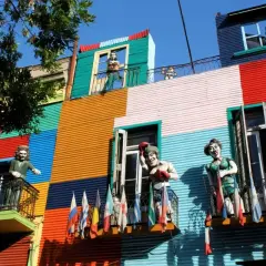Kolorowe kamienice w Buenos Aires, z figurami ludzi na balkonach. Czy w Argentynie jest bezpiecznie? Turyści chętnie odwiedzają tę barwną dzielnicę.