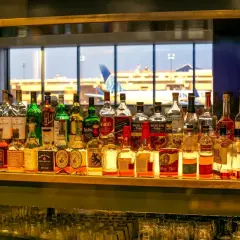 Na lotnisku można pić alkohol, co widać po bogatym wyborze butelek z whisky i innych trunków na barze, z widokiem na samoloty.