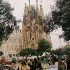 Tłum ludzi podziwia Sagrada Familia. Zastanawiasz się, ile się leci do Barcelony, by zobaczyć to cudo architektury?