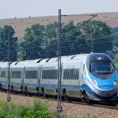 Pendolino na tle krajobrazu z sianem na wzgórzu.