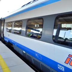 Pociąg PKP Intercity na peronie. Dowiedz się, jak wyrobić kartę seniora PKP, by podróżować taniej.