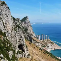 Gibraltar, czy to państwo? Majestatyczna skała z budynkami i morzem.