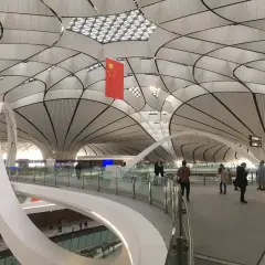 Nowoczesne lotniska w Chinach zachwycają architekturą. Wnętrze terminalu z flagą Chin i futurystycznym dachem.
