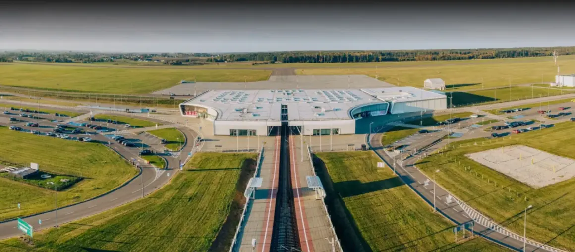 Nowoczesny terminal lotniska w Lublinie, otoczony polami i parkingami.