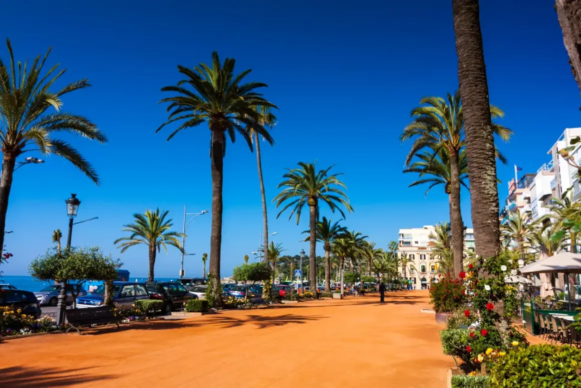 Promenada w lloret de mar centrum z palmami, kawiarniami i widokiem na morze.