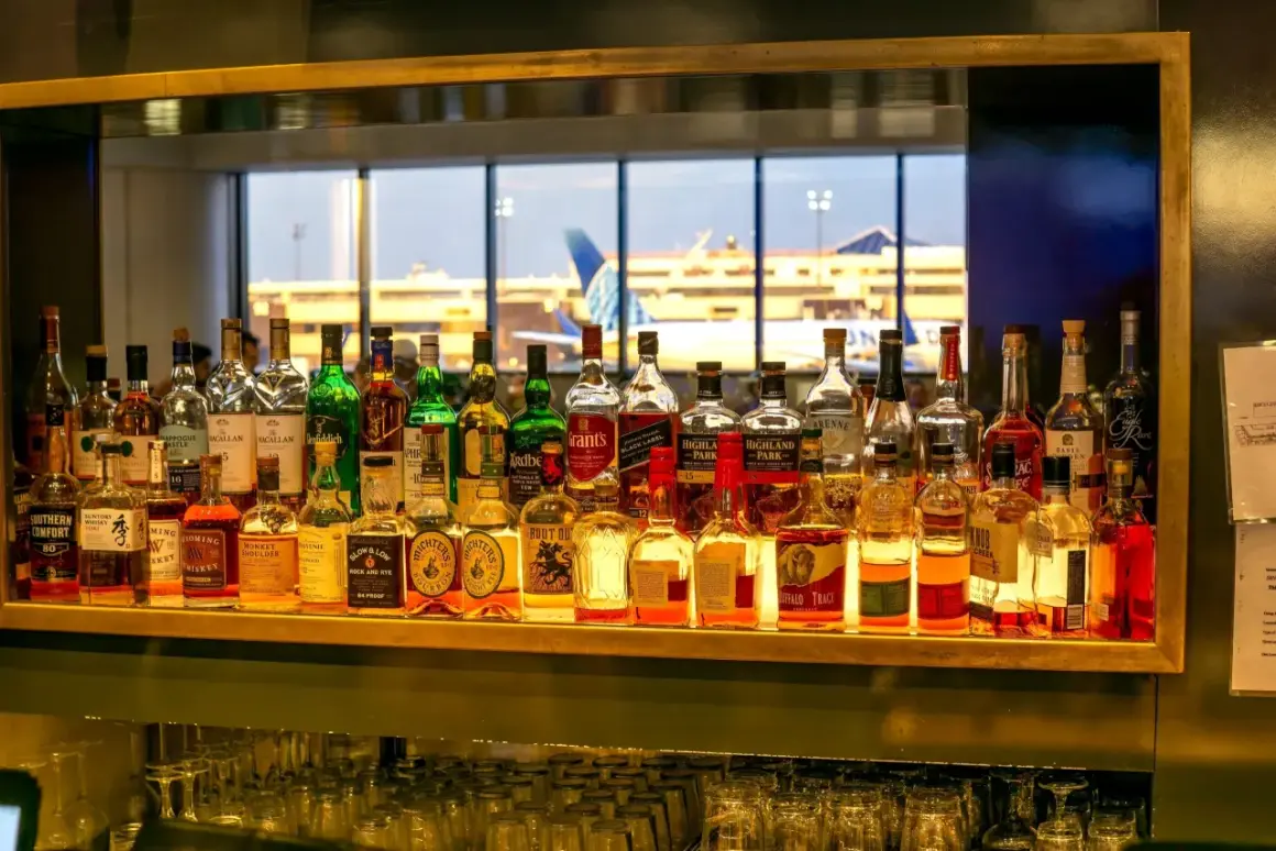 Na lotnisku można pić alkohol, co widać po bogatym wyborze butelek z whisky i innych trunków na barze, z widokiem na samoloty.