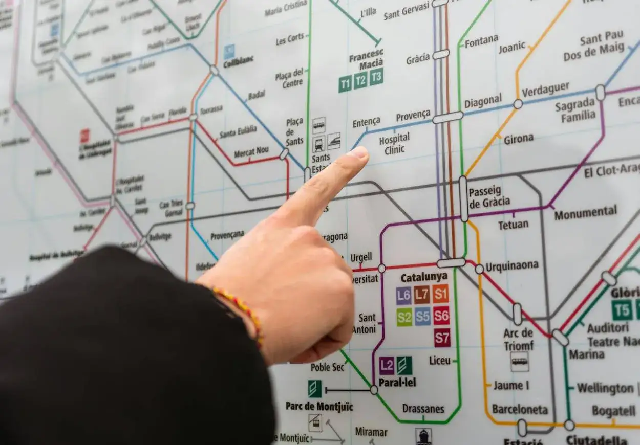 Palec wskazujący na mapę metra w Barcelonie, szukając połączenia z lotniskiem.