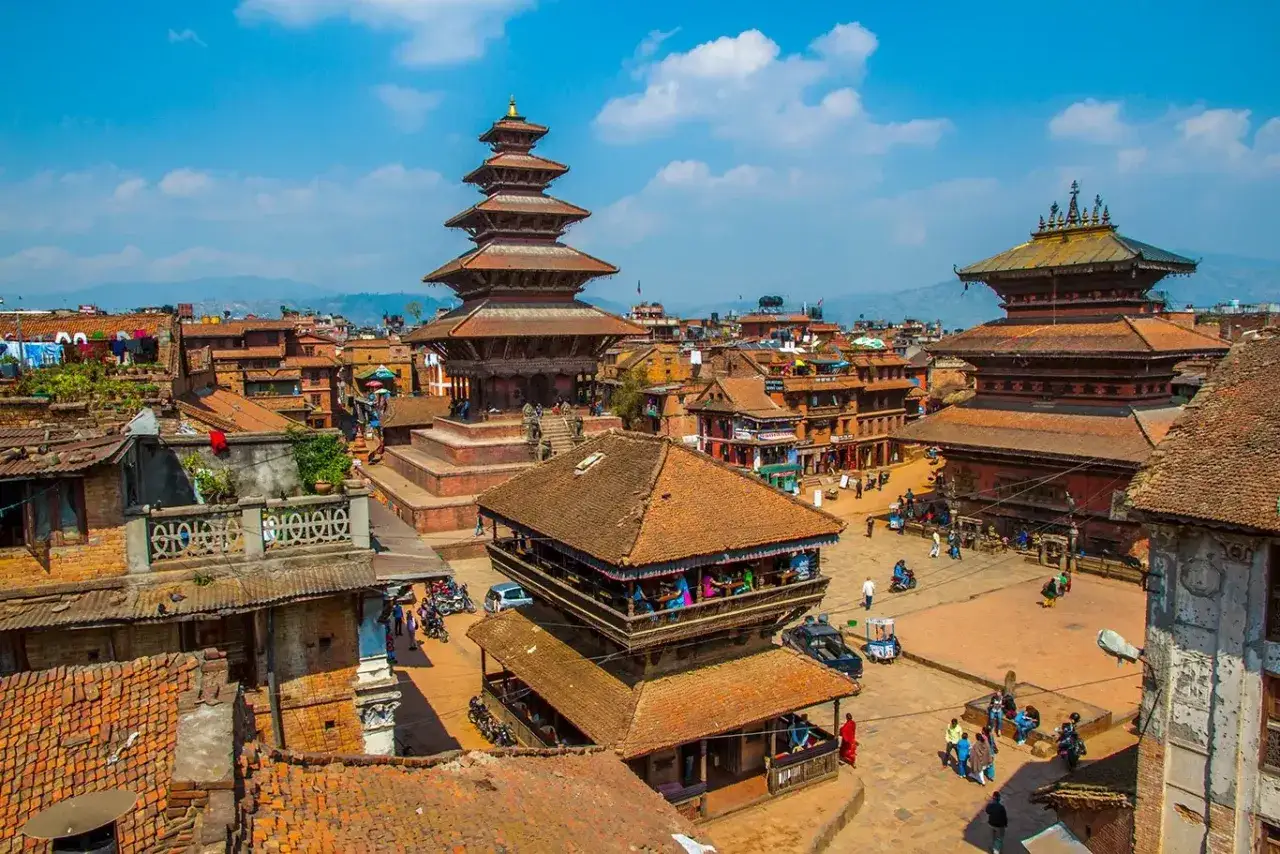 Tętniący życiem plac w Bhaktapur, gdzie jest Nepal. Widać wielopoziomowe pagody i tradycyjną architekturę.