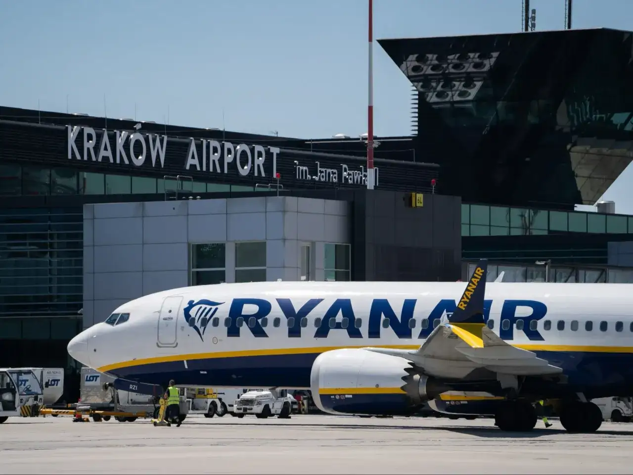 Samolot Ryanair na tle lotniska w Krakowie. W tle widoczny napis 