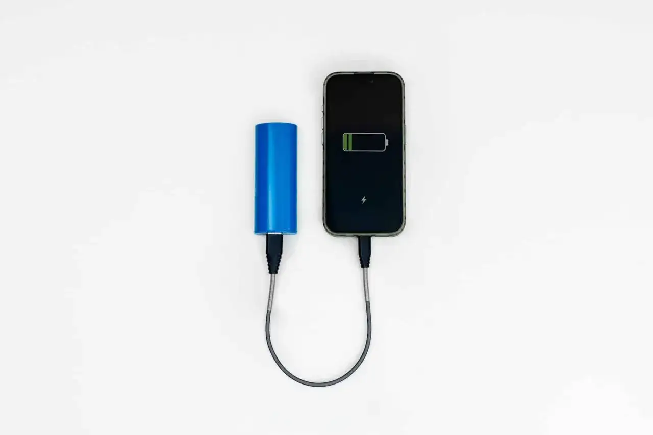 Niebieski wizzair powerbank ładuje telefon. Wygoda w podróży, gdy bateria pada.