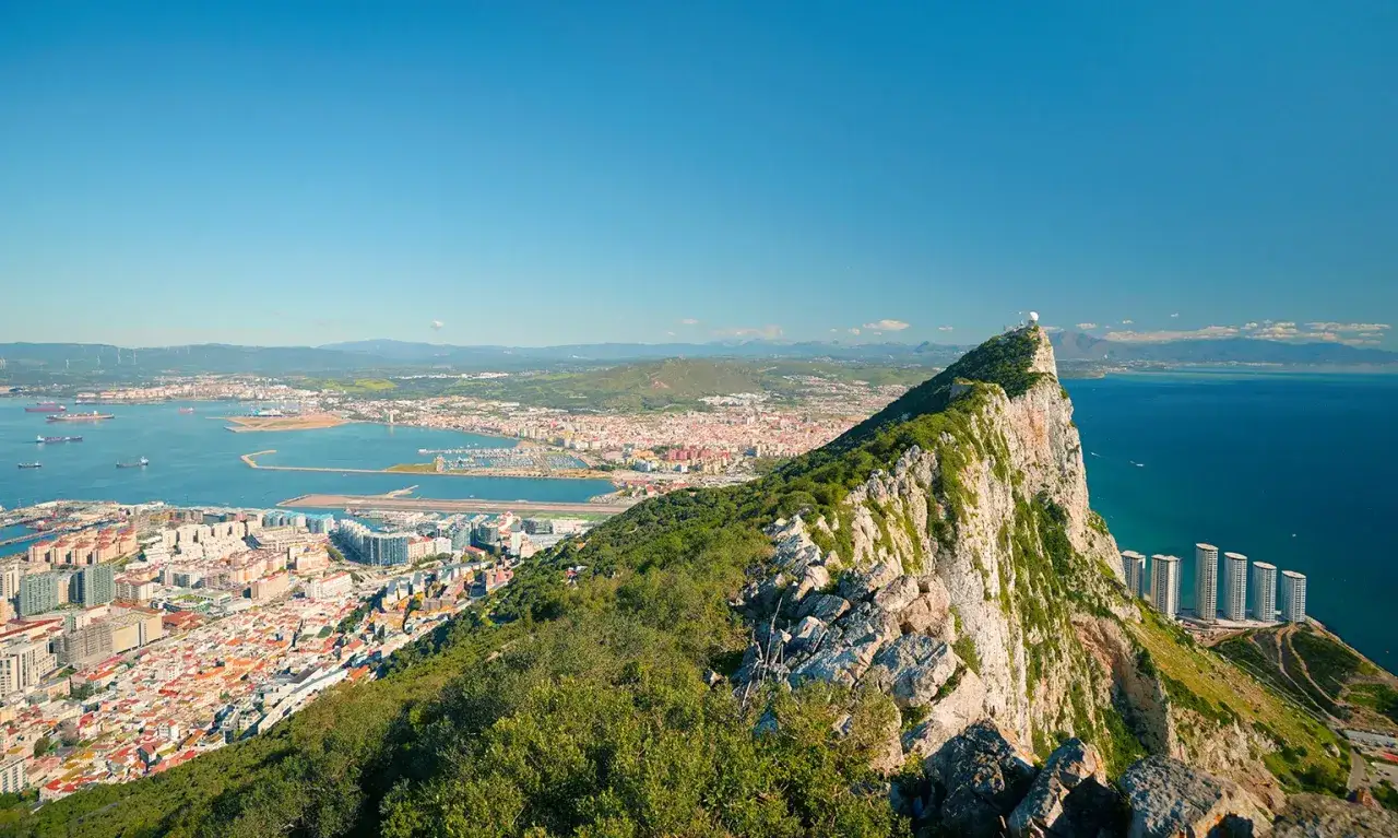 Widok na Gibraltar, skaliste wzniesienie z zabudowaniami i portem. Czy Gibraltar to państwo? To terytorium zamorskie Wielkiej Brytanii.