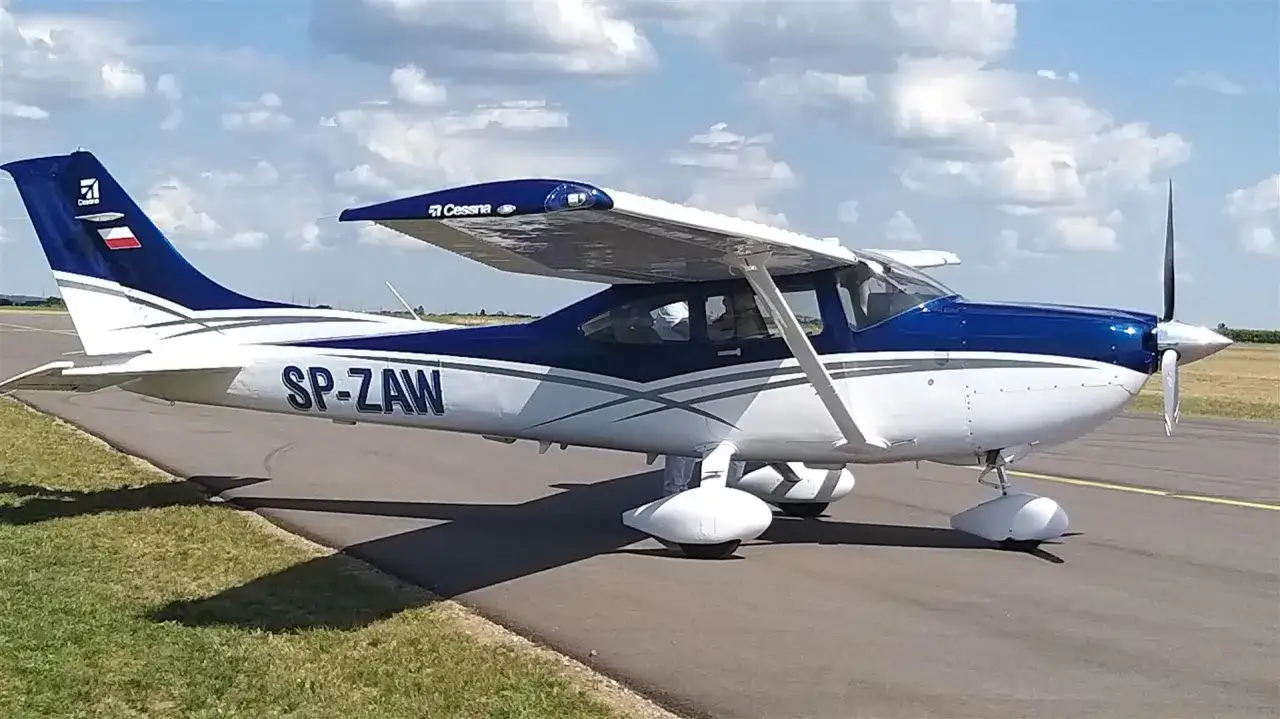 Niebiesko-biały samolot Cessna SP-ZAW na płycie lotniska, symbol polskich linii lotniczych.