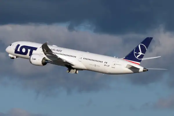Biały Dreamliner LOT-u wznosi się na tle burzowych chmur. To dumny element polskiej floty lotniczej.