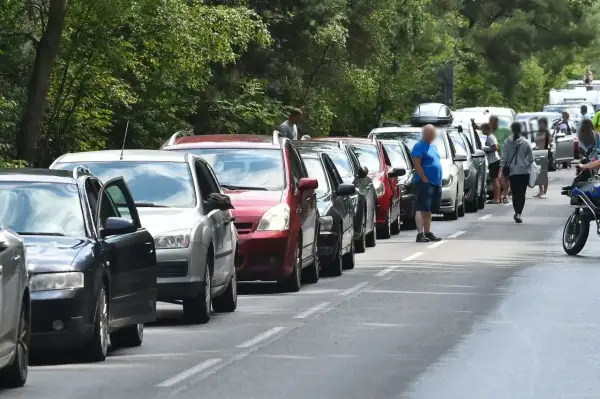 Długi korek samochodów na drodze do Helu, Gdańsk. Kierowcy stoją w upale, czekając na przejazd.