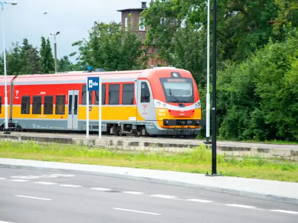 Czerwono-żółty pociąg Polregio na tle zieleni. Czy w Polregio jest rezerwacja miejsc?