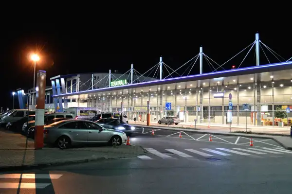 Nocne lotnisko, Terminal A, z autami i autokarami. Może to być podróż z Rzeszowa do Katowic.