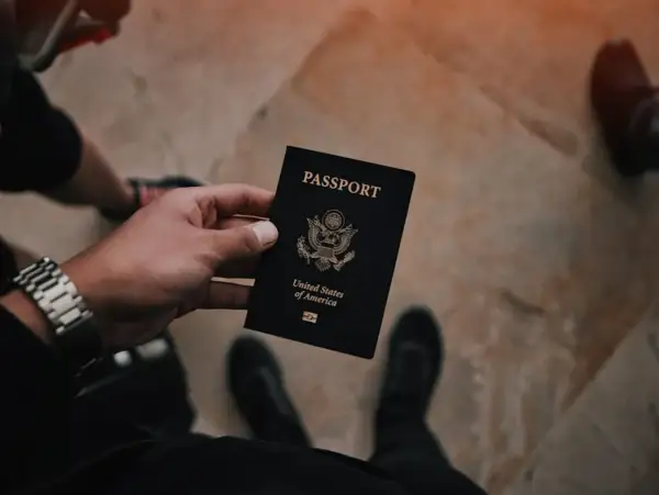 Dłoń trzyma czarny paszport USA. Czas na złożenie wniosku o paszport i rozpoczęcie podróży.