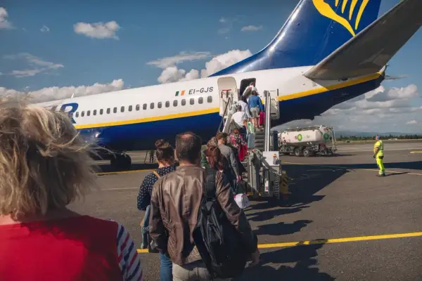 Pasażerowie wsiadają do samolotu Ryanair. Zastanawiasz się, ile kosztuje odprawa na lotnisku Ryanair?