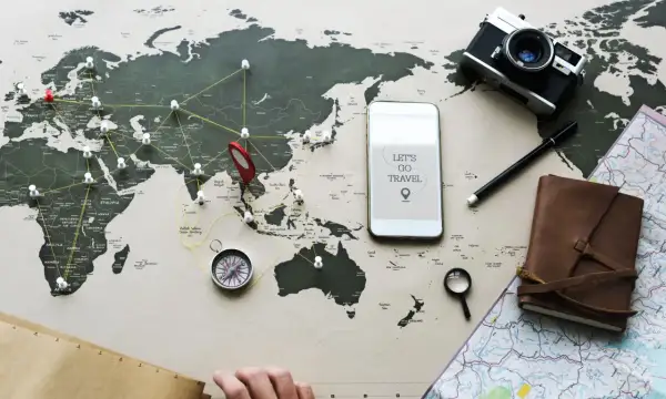 Planujesz podróż? Z mbank ubezpieczenie podróżne masz spokój ducha. Mapa świata, aparat, kompas i telefon z hasłem "Let's go travel" zachęcają do odkrywania świata.