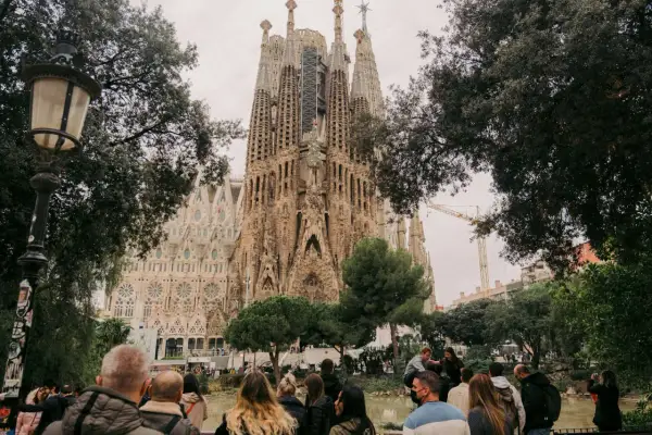 Tłum ludzi podziwia Sagrada Familia. Zastanawiasz się, ile się leci do Barcelony, by zobaczyć to cudo architektury?