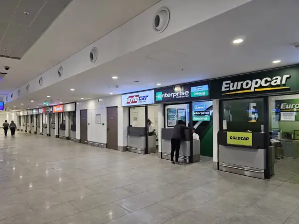 Kasa wypożyczalni samochodów na lotnisku w Antalyi. Widać szyldy Europcar, Enterprise, Avis i innych.