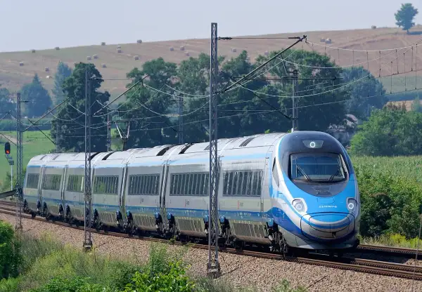 Pendolino na tle krajobrazu z sianem na wzgórzu.