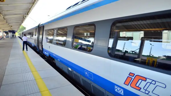 Pociąg PKP Intercity na peronie. Dowiedz się, jak wyrobić kartę seniora PKP, by podróżować taniej.