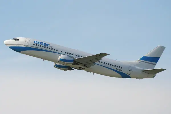 Boeing 737-700 Enter Air wznosi się na błękitne niebo.