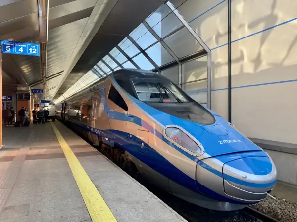 Nowoczesny pociąg InterCity w kolorach niebieskim i srebrnym stoi na peronie.